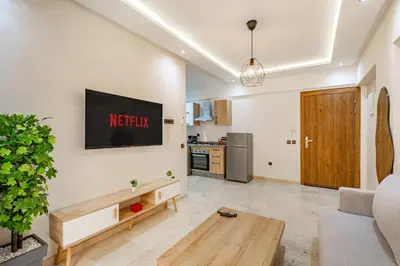 a living room with a television on a wall at Jolie & Luxueux Appart a Gueliz - 100% Équipé in Marrakech