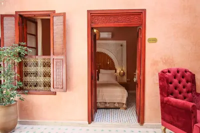 a bedroom with a bed and a mirror and a chair at RIAD MARRAKECH DOORS in Marrakech