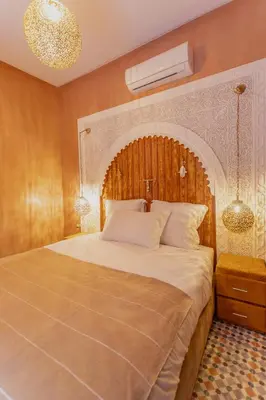 a bedroom with a large bed with a wooden headboard at RIAD MARRAKECH DOORS in Marrakech