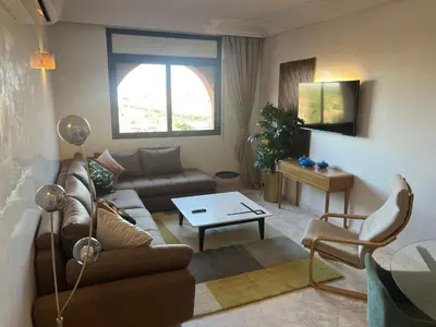 a living room with a couch and a table at Appartment le bleu in Marrakech