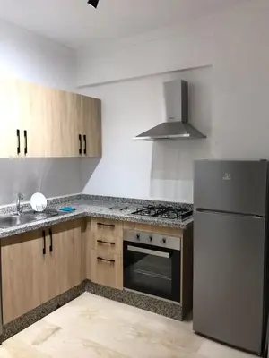 a kitchen with a refrigerator and a stove top oven at Superbe appartement uniquement pour les familles in Marrakech