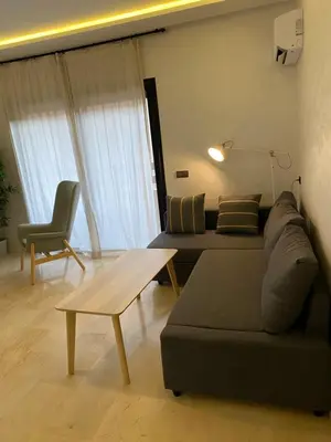 a living room with a couch and a table at Superbe appartement uniquement pour les familles in Marrakech