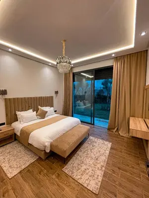 a bedroom with a large bed and a chandelier at Villa 7palms in Marrakech