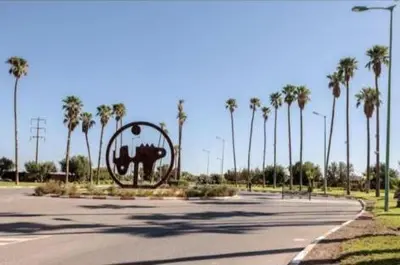a sculpture in the middle of a road with palm trees at appartement in Marrakech