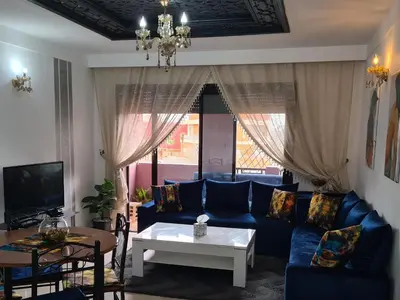 a living room with a blue couch and a table at appartement in Marrakech