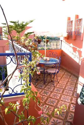 a patio with a table and chairs on a balcony at Chez Peyo in Marrakech