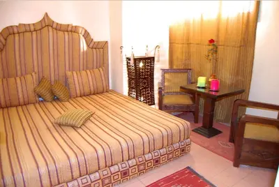 a bedroom with a bed and a table and a chair at Chez Peyo in Marrakech
