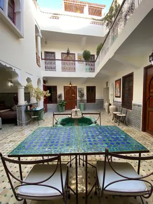 a courtyard with a table and chairs in a building at Riad Dar Teranga Hotel & Spa in Marrakech