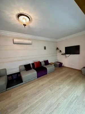 a living room with a couch and a flat screen tv at Appartement chambre salon a l'hivernage 9 in Marrakech