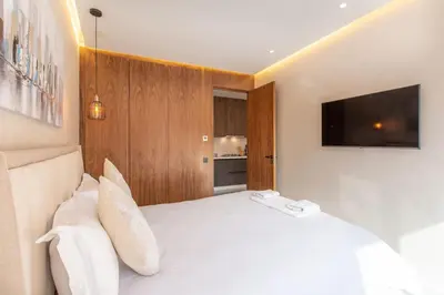 a bedroom with a white bed with a flat screen tv at New ! Stunning and Comfortable apartement in Marrakech