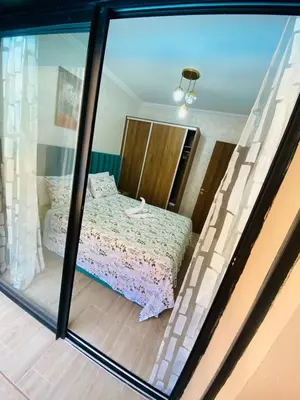 a bedroom with a bed through a glass window at appart à côté de la gare du train in Marrakech
