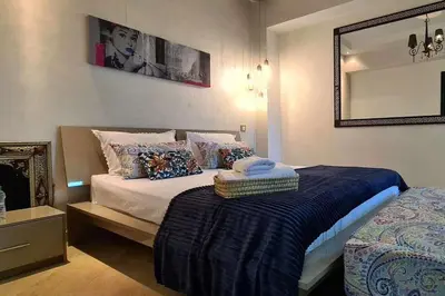 a bedroom with a bed and a mirror on the wall at Luxueux appartement Marrakech au cœur de l hivernage in Marrakech