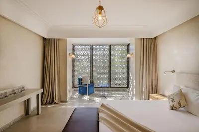 a hotel room with a bed and a large window at Villa de luxe Sahara in Marrakech