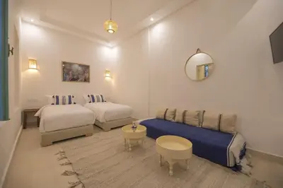 a hotel room with two beds and a couch at Riad l'Esprit des Patios & Spa in Marrakech