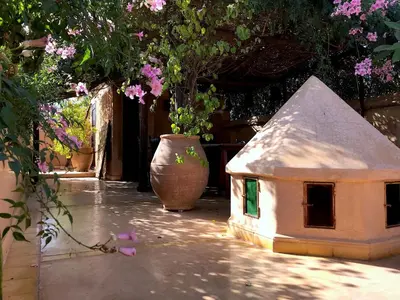 a small bird house sitting on a patio with flowers at Riad Dar Dallah in Marrakech