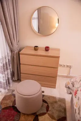 a bedroom with a mirror and a dresser with a stool at Beautiful, great equipped 122 m holiday apartment near Majorelle Garden and Gueliz with pool views and a large balcony and terrace in Marrakech