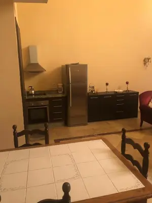a kitchen with a stainless steel refrigerator and a table at Propre appartement à loué pour les familles in Marrakech