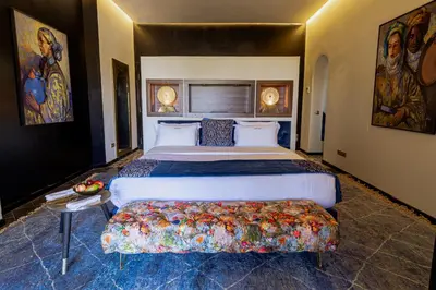 a bedroom with a king sized bed with a bench in it at Palais Anthea Boutique Hotel & Spa in Marrakech
