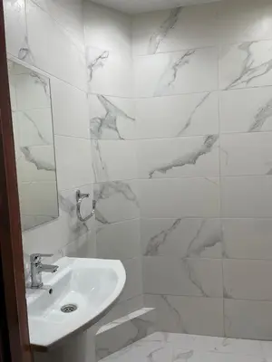 a white bathroom with a sink and a mirror at Appartement dans résidence avec piscine in Marrakech