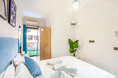 a bedroom with a white bed with blue pillows at Magnificent Apartment in Gueliz - 100% Equipped in Marrakech