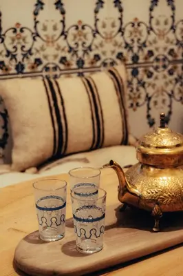 a tray with three glasses and a tea kettle at Riad Fz Marrakech in Marrakech