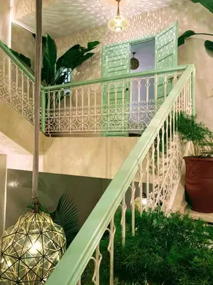 a white staircase with a green railing and plants at Riad with Outdoor Swimming Pools in Marrakech
