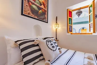 a bedroom with a bed and a painting on the wall at SABOR SAFRA in Marrakech