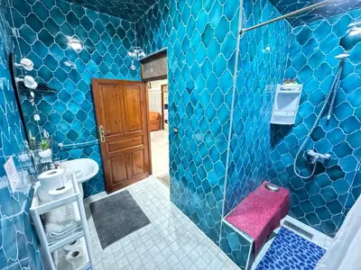 a bathroom with blue tiled walls and a pink stool at Marrakech aRt in Marrakech