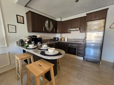 a kitchen with a table with chairs and a counter top at Bagatelle House 2 in Marrakech
