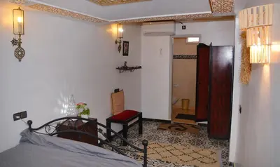 a bedroom with a bed and a chair in a room at Araf House in Marrakech