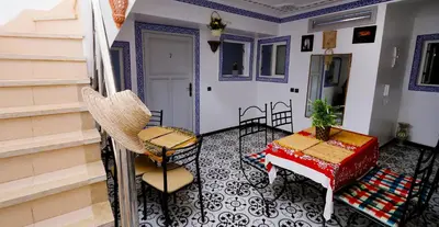 a room with a table and chairs on a balcony at Araf House in Marrakech