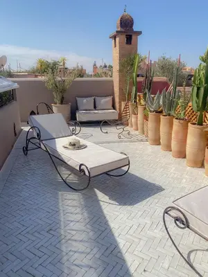 a patio with a table and a couch on a patio at Riad Dar Marrakcha in Marrakech