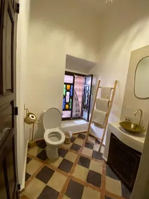 a bathroom with a toilet and a sink and a window at Riad Musa in Marrakech