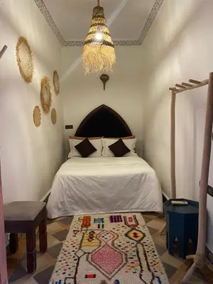 a bedroom with a bed and a rug on the floor at Riad Musa in Marrakech