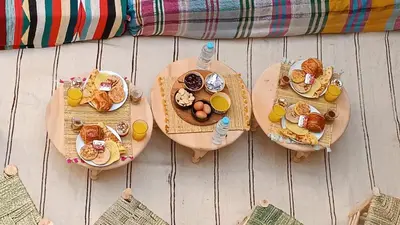 a table with three plates of breakfast foods and orange juice at Happy Marrakchy in Marrakech