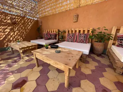 a patio with two benches and a wooden table at Happy Marrakchy in Marrakech