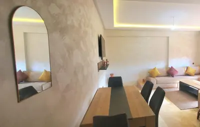 a dining room with a table and a mirror at Appartement tout neuf en plein centre de Marrakech in Marrakech