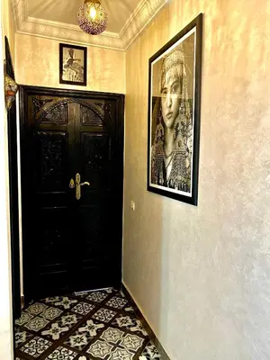 a hallway with a black door and a picture on the wall at Riad Dar IMANE in Marrakech