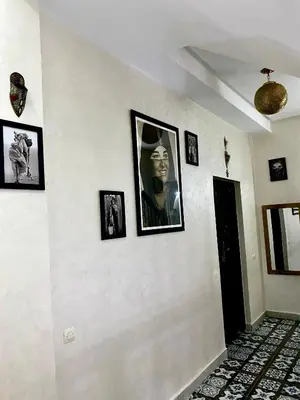 a hallway with framed pictures on a white wall at Riad Dar IMANE in Marrakech