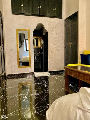 a bedroom with a marble floor and a mirror at Riad Dar IMANE in Marrakech