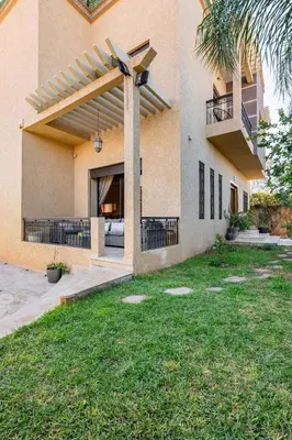 a house with a patio and a yard with grass at Marrakech le joyau villa piscine privée jardin in Marrakech