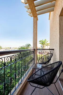 a balcony with two chairs and a view of the ocean at Marrakech le joyau villa piscine privée jardin in Marrakech