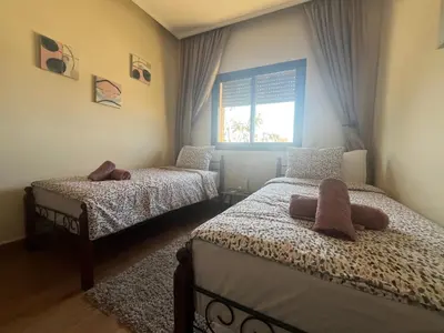 a bedroom with two beds and a window at Marrakech le joyau villa piscine privée jardin in Marrakech