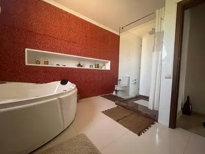 a bathroom with a tub and a red wall at Marrakech le joyau villa piscine privée jardin in Marrakech