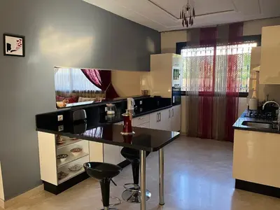 a kitchen with a black counter top in a room at Marrakech le joyau villa piscine privée jardin in Marrakech