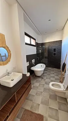 a bathroom with a tub and a toilet and a sink at Villa M Piscine chauffée, Hammam sans vis à vis Marrakech in Marrakech