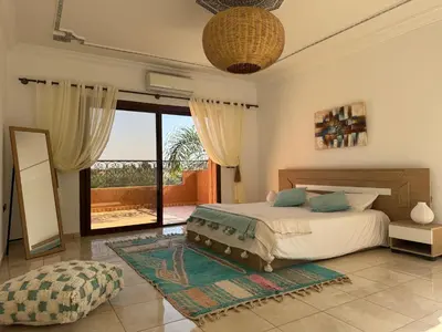 a bedroom with a bed and a large window at Maison Jannate Louise in Marrakech