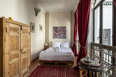 a bedroom with a bed and a red curtain at Riad le Jardin de Mina in Marrakech