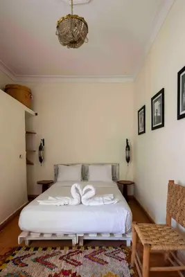 a bedroom with a bed with two white towels on it at Riad le Jardin de Mina in Marrakech