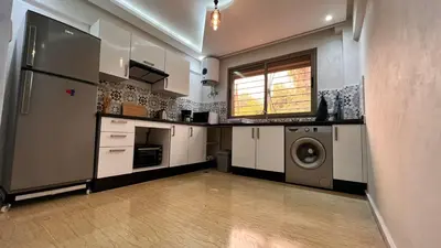 a kitchen with white cabinets and a washer and dryer at Duplex haut standing, 3 chambres ,Marrakech,gueliz in Marrakech